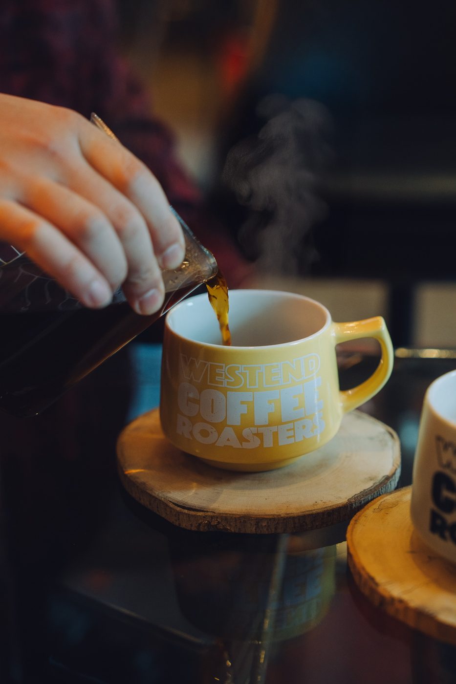 WESTEND COFFEE ROASTERS の黄色いマグにコーヒーを注いでいるところ